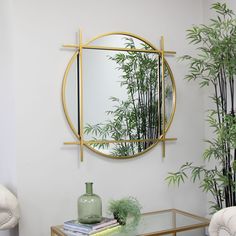 a living room with a round mirror on the wall next to a table and chair