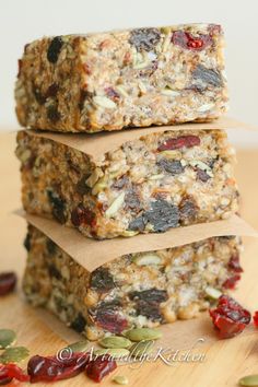 three granola bars stacked on top of each other with cranberries and sunflower seeds