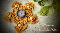 a crocheted doily with a lit candle on it next to some leaves