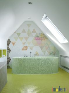 a bathroom with a green bathtub next to a white sink and window above it