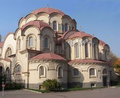 a large building with many windows and arches on it's sides, in the middle of a parking lot