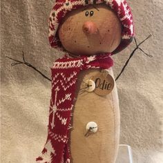 a wooden snowman with a red hat and scarf