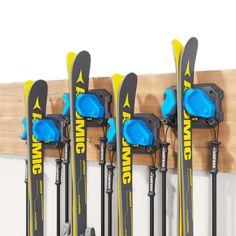 there are many skis hanging on the wall with blue cups in front of them