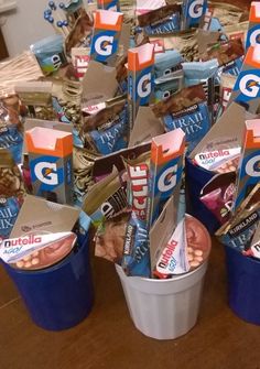 several buckets filled with snacks sitting on top of a wooden table next to each other