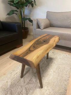 a wooden bench sitting on top of a rug in a living room next to a couch