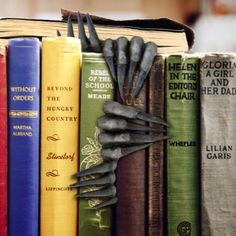 a book shelf filled with lots of books and an umbrella sticking out of the top