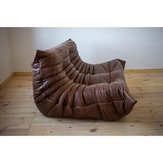 a brown leather chair sitting on top of a wooden floor