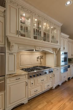 a large kitchen with white cabinets and wood floors