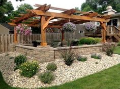 an outdoor patio area with stone walls and wooden pergols on the side of it