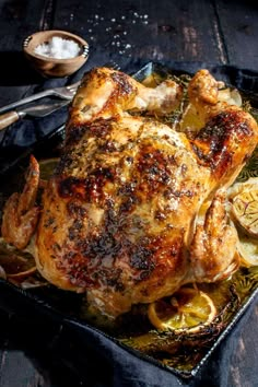 a roasted chicken on a tray with potatoes and garlic