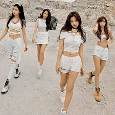 the girls are walking down the road in white outfits and high heels, all wearing short shorts