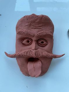 a clay mask with a fake mustache on it