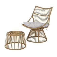 a wicker chair and footstool with a white pillow on the backrest