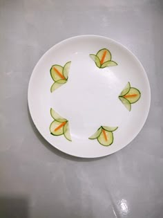 a white plate with orange and green flowers on it