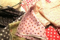 several cloths are stacked on top of each other with polka dots and flowers all over them