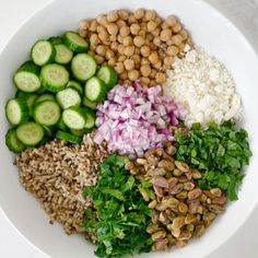 a white bowl filled with different types of vegetables and grains on top of each other