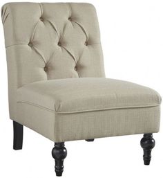 an upholstered beige chair with black legs