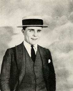 an old photo of a man in a suit and hat