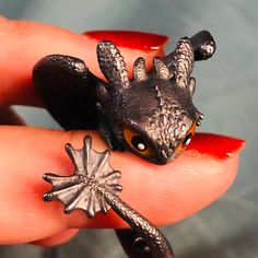 a tiny toy animal sitting on top of a persons finger