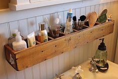 a wooden shelf filled with lots of bathroom items next to a white sink in a bathroom