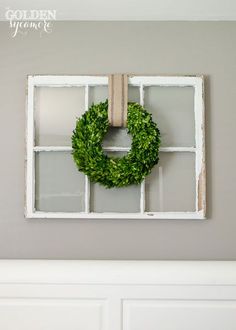 a white window frame with a wreath hanging on it