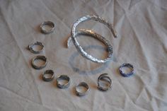 an assortment of silver rings on a white sheet