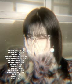 a woman with glasses covering her face in front of a computer screen that has text on it