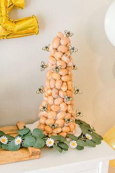 a cake made out of peanuts sitting on top of a table next to balloons and flowers