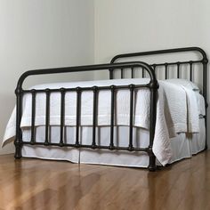 a black metal bed frame with white sheets