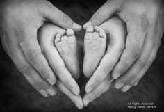 two people holding their hands in the shape of a baby's foot and heart