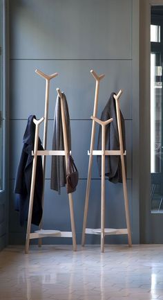 two wooden clothes racks sitting next to each other