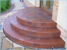 a set of steps leading up to a door on a brick walkway in front of a house