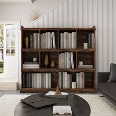 a living room filled with furniture and a book shelf next to a couch on top of a rug