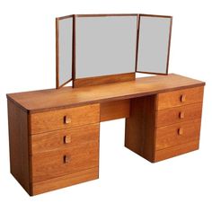 a wooden desk with two mirrors on top of it, and drawers underneath the table