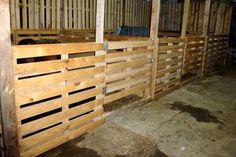 the inside of a barn with wooden stalls