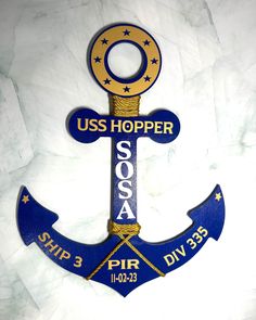 a blue and gold anchor with the words uss hopper soca on it's side