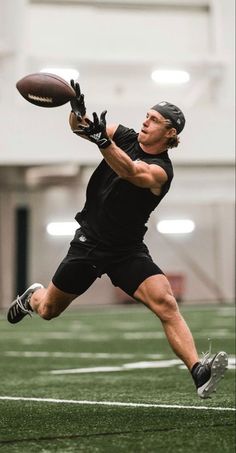 a man catching a football on top of a field