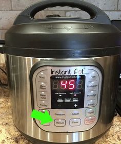 an instant pot is sitting on the counter top next to a digital clock and oven