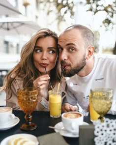 a man and woman sitting at a table with drinks