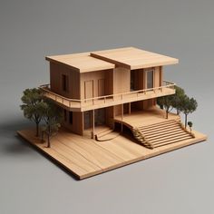 a wooden model of a house with trees on the outside and stairs leading up to it