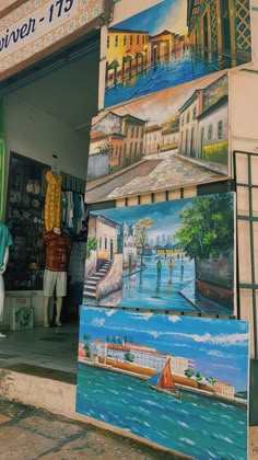 there are many paintings on display outside the store