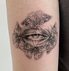 a woman's arm with an eye and butterflies on it