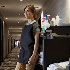 a woman standing next to a bed in a hotel room