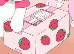 a pink box with strawberries on it and a stuffed animal sitting next to it