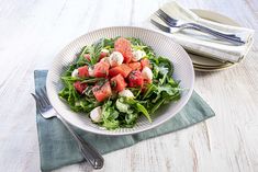 a salad with watermelon and mozzarella in a bowl on a table