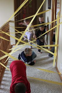 children playing with tape on the floor in front of an open door and staircase leading to another room