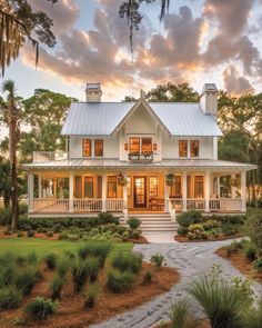 a large white house with lots of windows on the front and side of it, surrounded by trees