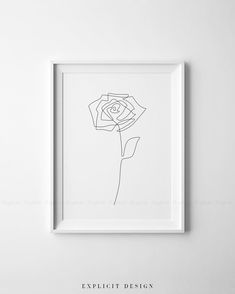 a black and white drawing of a single rose in a square frame on a wall