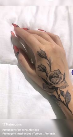 a woman's hand with a rose tattoo on it