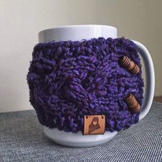 a knitted coffee cup cozying with wooden buttons